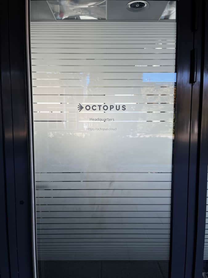 Türenfensterbeschriftung mit Milchglas und vertikalen Streifen.